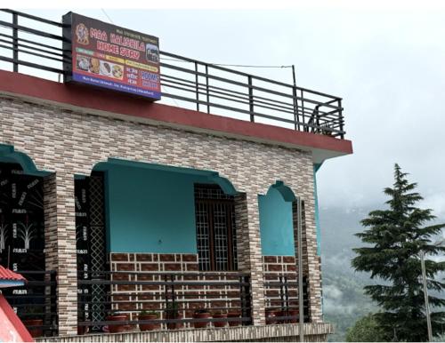 a building with a sign on top of it at maa kalishila home stay in Ukhimath