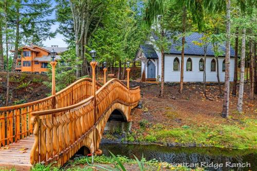 a wooden bridge over a stream with a house in the background at Private Ranch 2BR Cabin Retreat Sleeps 9 in Anacortes