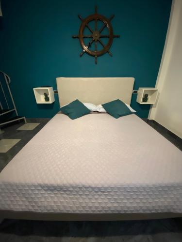 a bedroom with a white bed with a steering wheel on the wall at La dimora del marinero in San Benedetto del Tronto
