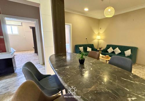 a living room with a large table and chairs at البندقية للخدمات الفندقية BQ HOTEL SUITES in Buraydah