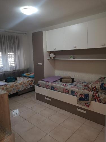 a bedroom with two beds and white cabinets at Nido del Melo in Cles