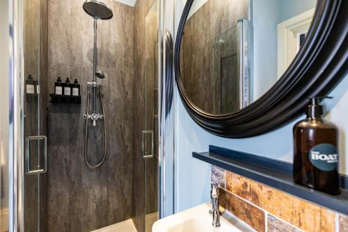 a bathroom with a shower and a sink with a mirror at The Boat House Luxury Apartments Scarborough in Scarborough