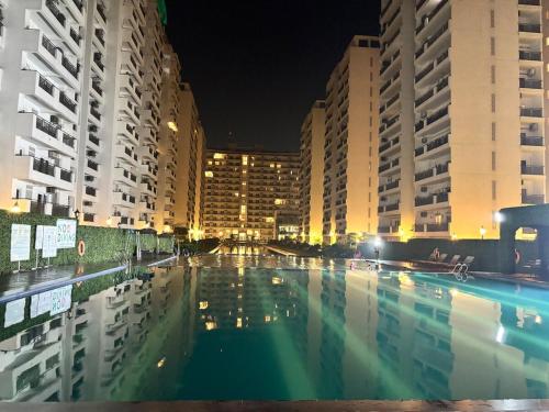 a large swimming pool in a city at night at Valley of us in Sohna