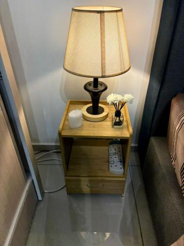 a lamp on a night stand next to a bed at Taman Equine comfy studio, high-end facilities in Seri Kembangan