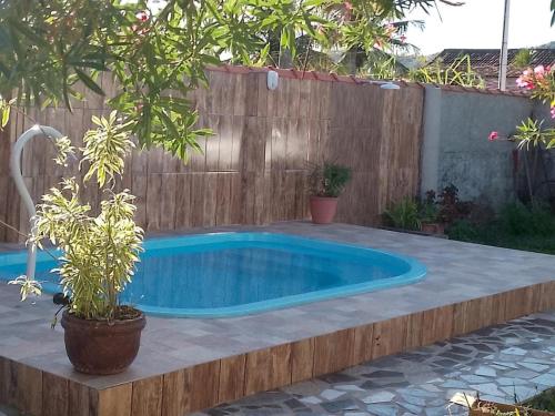 a swimming pool in a backyard with a wooden fence at Casa de temporada piscina com proxima a praia in Saquarema