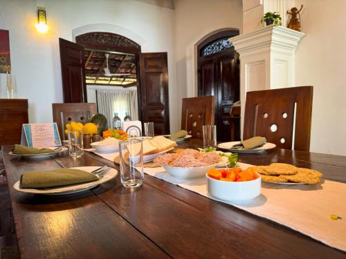 a wooden table with bowls of food on it at Cee Shade Villa - Maha Induruwa in Bentota