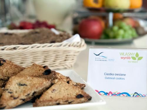 a plate of cookies and a basket of fruit at Hotel Nadmorski in Gdynia