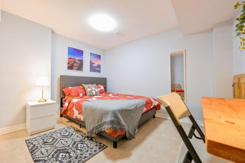 a bedroom with a bed and a table and a desk at Stylish 2BR: w/free parking & streaming! in Pickering
