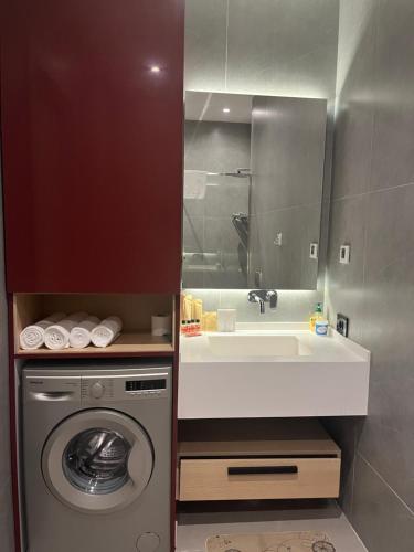 ein Badezimmer mit Waschbecken und Waschmaschine in der Unterkunft Sea Breeze Polo Residences - One bedroom apartment in Nardaran