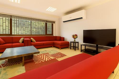 a living room with a red couch and a flat screen tv at 34 Yüksel Garden in Ankara