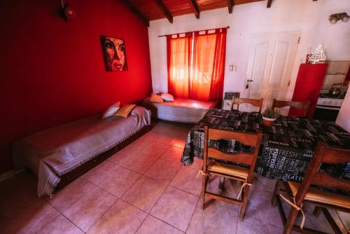 ein rotes Zimmer mit einem Bett und einem Tisch und Stühlen in der Unterkunft Casas de Campo in Villa Urquiza