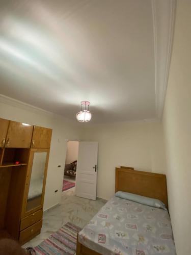 a bedroom with a bed and a light on the ceiling at ڤيلا في الساحل الشمالي in Borg El Arab