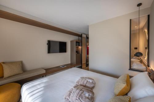 a bedroom with a white bed and a couch at Alchimia WellResort in Comano Terme