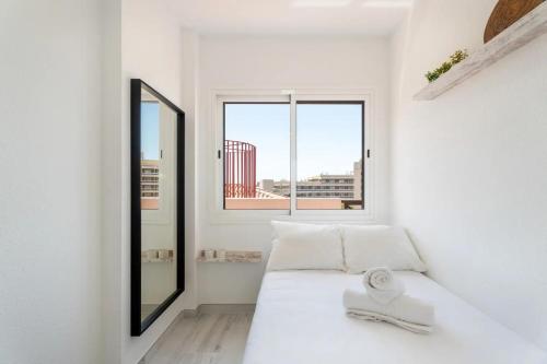 een witte kamer met een bed en een raam bij Ático 3 Palmeras Albatros in San Miguel de Abona