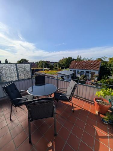 a patio with a table and chairs on a balcony at Ferienwohnung mit Seeblick in Plön