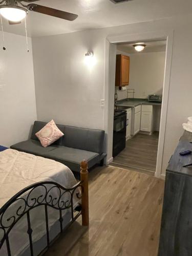 a bedroom with a bed and a couch and a kitchen at TAYLOR 1 BEDROOM SUITE FULL KITCHEN PRIVATE GATED YARD ARTS RooSEVELT ROW CONVENTION CENTER STADIUMS ASU airport DOWNTOWN PHOENIX in Phoenix