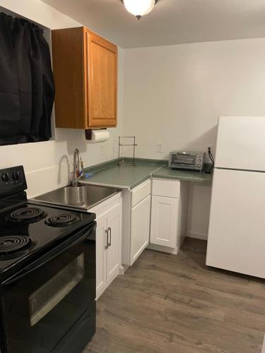 a kitchen with a black stove and a white refrigerator at TAYLOR 1 BEDROOM SUITE FULL KITCHEN PRIVATE GATED YARD ARTS RooSEVELT ROW CONVENTION CENTER STADIUMS ASU airport DOWNTOWN PHOENIX in Phoenix