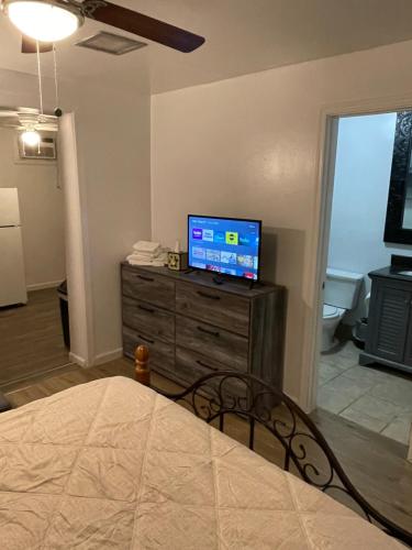 a bedroom with a bed and a television on a dresser at TAYLOR 1 BEDROOM SUITE FULL KITCHEN PRIVATE GATED YARD ARTS RooSEVELT ROW CONVENTION CENTER STADIUMS ASU airport DOWNTOWN PHOENIX in Phoenix