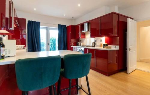 Spacious 3 bed Parking, Long stay , Relocators في ناريسبورو: مطبخ مع خزائن حمراء وكراسي زرقاء