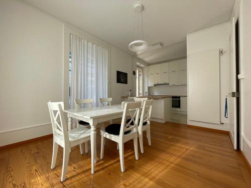 a white dining room table and chairs in a room at Bellavista in Neuchâtel