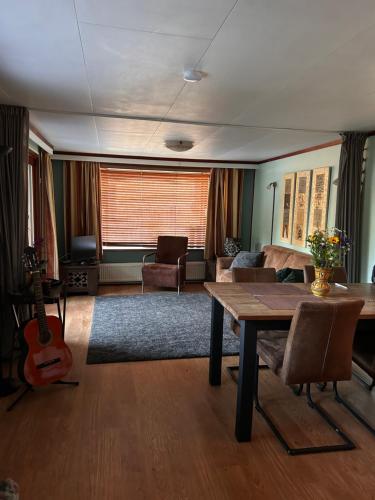a living room with a table and a guitar at Welcome, relax and enjoy your stay in Putten