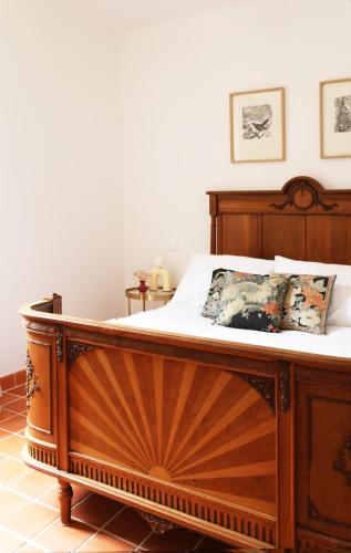 a wooden bed with white sheets and pillows on it at House Nestled in the Forest in Vieux-Viel