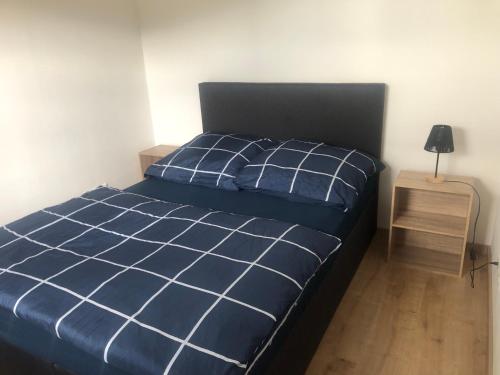 a bedroom with a blue bed and a night stand at Urban Stay & Style in Parsberg