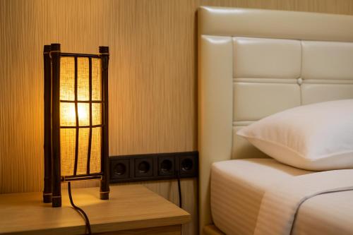 a bedroom with a bed and a lamp on a table at 34 Yüksel Garden in Ankara