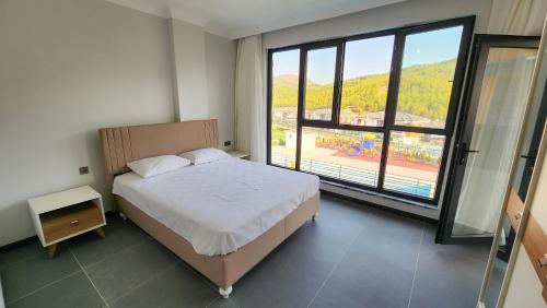 a bedroom with a bed and a large window at Villa Ala A4 Özel Havuzlu in Dalaman