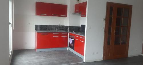 una pequeña cocina con armarios rojos y fregadero en A private room in a flat shared familly home, en Mulhouse