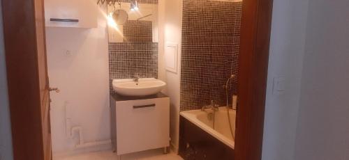 un baño con lavabo y bañera en A private room in a flat shared familly home, en Mulhouse