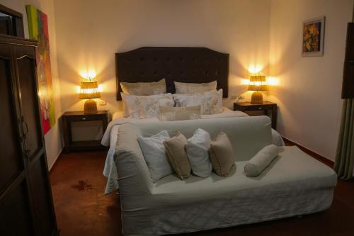 a bedroom with a white bed with pillows at Hotel Boutique Casa de Los Santos Reyes Valledupar in Valledupar