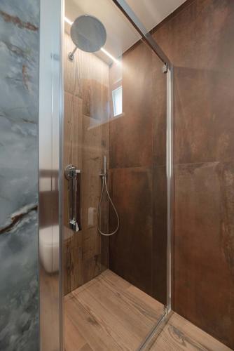 a shower with a glass door in a bathroom at Francesca's home in Pozza di Fassa