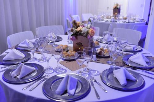 a table with plates and wine glasses on it at Little Ranch Hotel Spa Pilar in Manuel Alberti