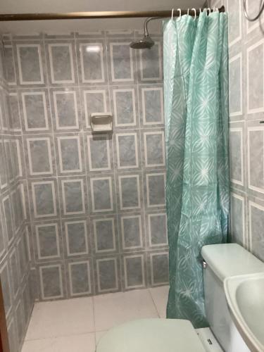 a bathroom with a shower curtain next to a toilet at Manizales premium stay in Manizales
