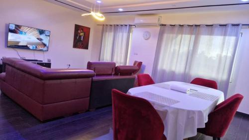 a meeting room with a table and chairs and a couch at Appartement red, classique et harmonieuse in Lomé