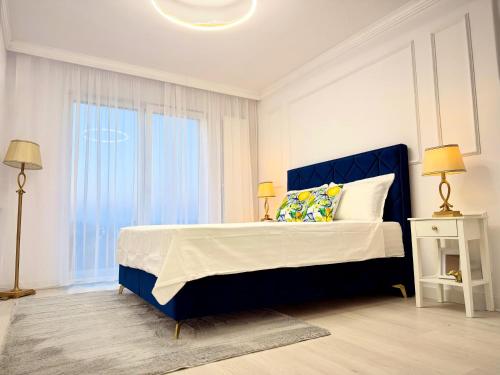 a bedroom with a blue bed and a window at Boutique Apartment in Ploieşti