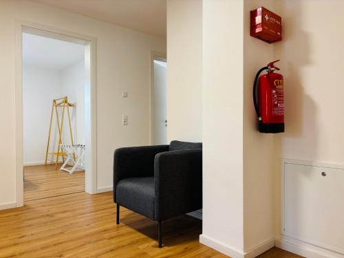 a living room with a red fire extinguisher on the wall at REMA Homes - Luxuriöse Apartments - Messenähe - Offenburg in Offenburg