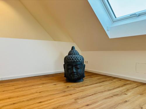 a statue sitting on a wooden floor in an empty room at REMA Homes - Luxuriöse Apartments - Messenähe - Offenburg in Offenburg