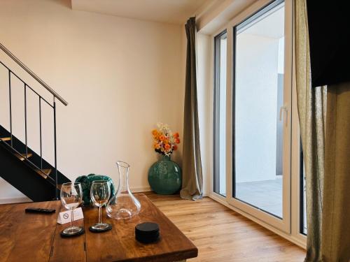 a room with a table with wine glasses on it at REMA Homes - Luxuriöse Apartments - Messenähe - Offenburg in Offenburg