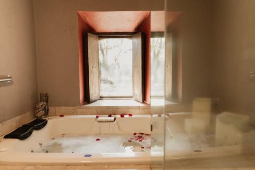 a bath tub in a room with a window at Hacienda Sepulveda Hotel & Spa in Lagos de Moreno