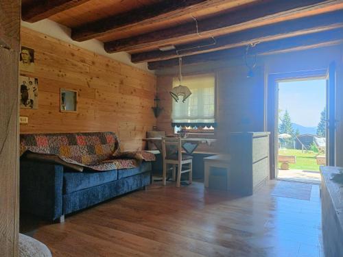 a living room with a blue couch and a table at Maso Clementina in Pieve Tesino