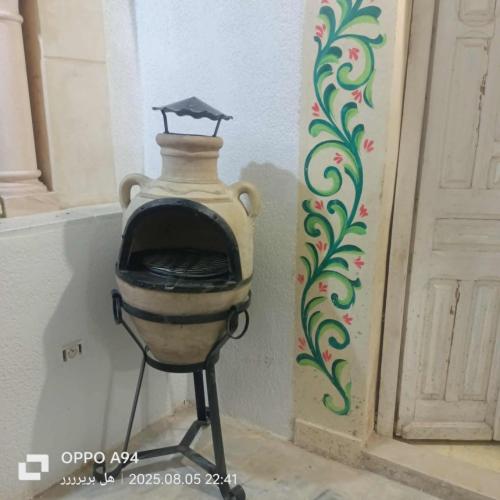 a vase sitting in a corner next to a door at Appartement Fell in Monastir