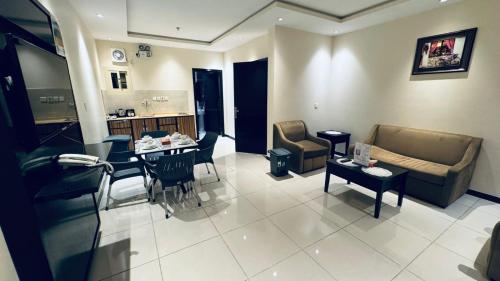 a living room with a couch and a table at شقق دار الفرسان المخدومة in Quai