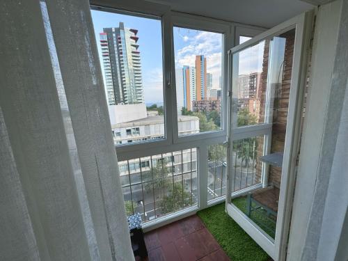 Cette chambre dispose de fenêtres offrant une vue sur la ville. dans l'établissement Apartamento Forum, à Barcelone