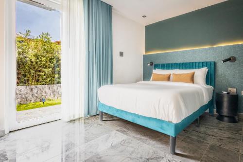 ein Schlafzimmer mit einem blauen Bett und einem großen Fenster in der Unterkunft La Diana - QueenRoom Pool - Resort Vibe Near Beach in San Juan