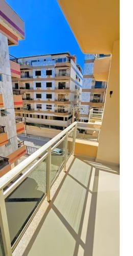 a balcony of a building with two tall buildings at Elegante Ap | 3 Quartos c/Ar | 100m Praia do Forte in Škorak