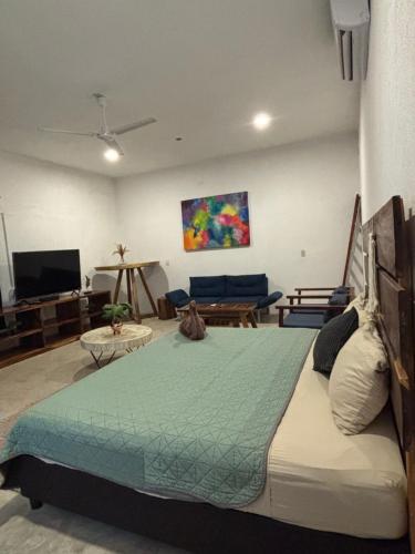 a bedroom with a large bed and a living room at Hidden Port TTipis Vista Carrizalillo in Puerto Escondido