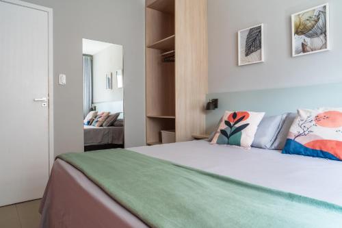 a bedroom with a bed with a green blanket at Elegante Ap | 3 Quartos c/Ar | 100m Praia do Forte in Škorak