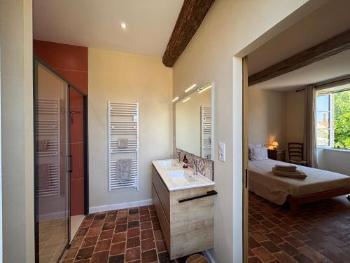 un bagno con lavandino e specchio di Le Prieuré Saint Pierre, gîtes et chambres d'hôtes dans un parc classé a Réaumur